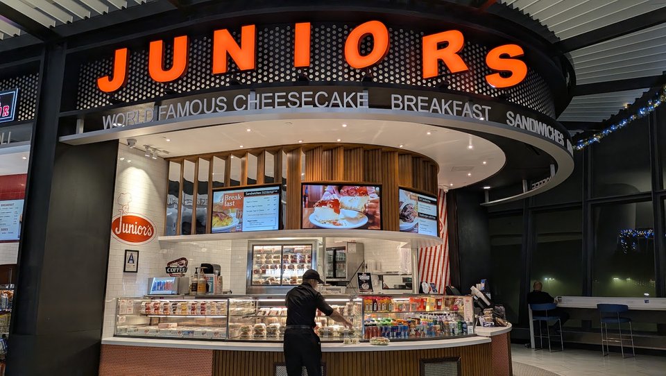 Airport restaurant entrance with casual seating nearby.